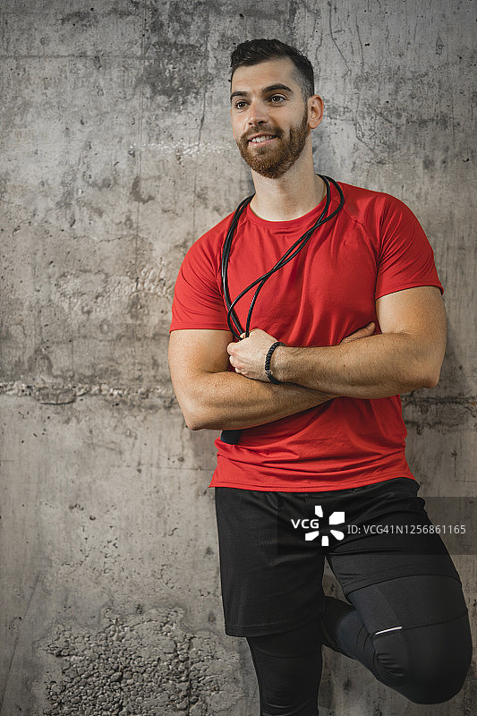 快乐的男性健身教练的肖像与跳绳孤立在灰色背景图片素材