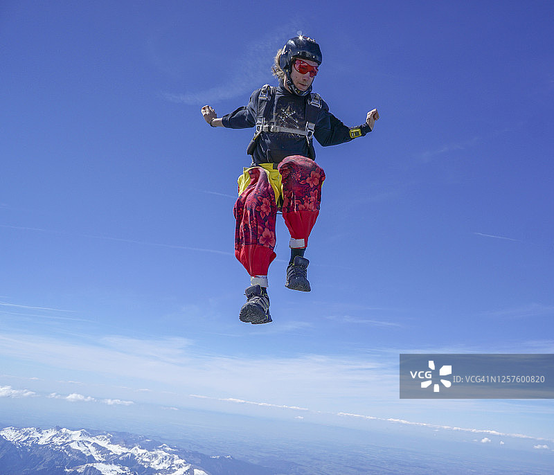 自由落体飞行者通过高山景观之上的崇高天空下降图片素材