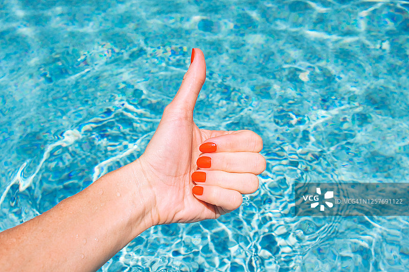 夏天在游泳池里涂红色指甲油，女人的认可图片素材