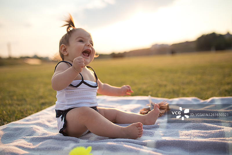 微笑的小女孩在公园玩玩具图片素材