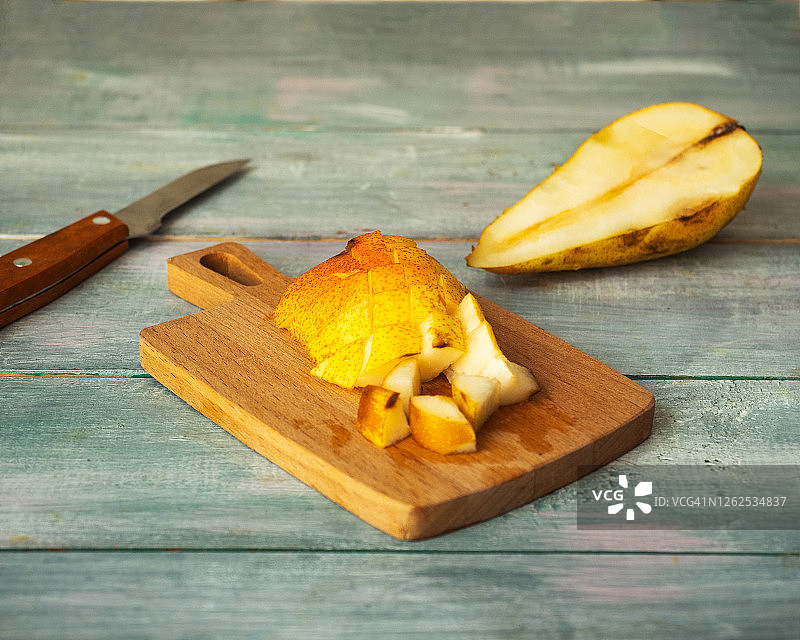 熟梨切片放在小厨板上，准备水果沙拉，菜刀图片素材