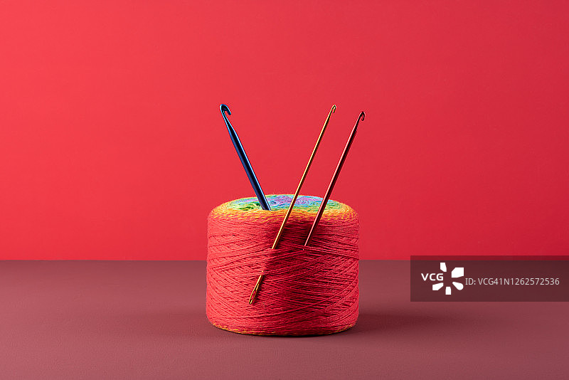 编织钩针钩与一个红色的羊毛球图片素材