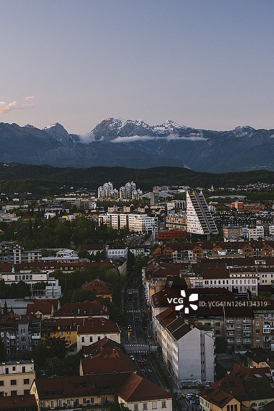 朱利安阿尔卑斯山在斯洛文尼亚日落卢布尔雅那城堡的背景。图片素材