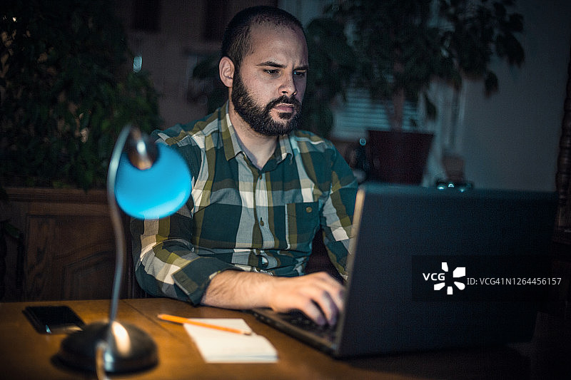 深夜在家里工作和使用笔记本电脑的人图片素材