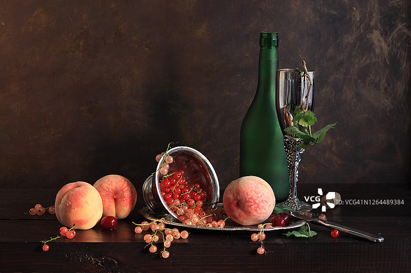 醋栗，桃子，绿色瓶子和金属酒杯图片素材