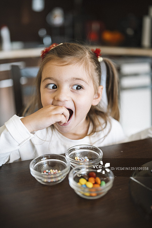 可爱的马尾辫小女孩正在吃糖果图片素材
