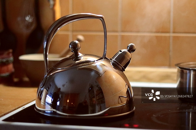 茶壶，在厨房的炉子上图片素材