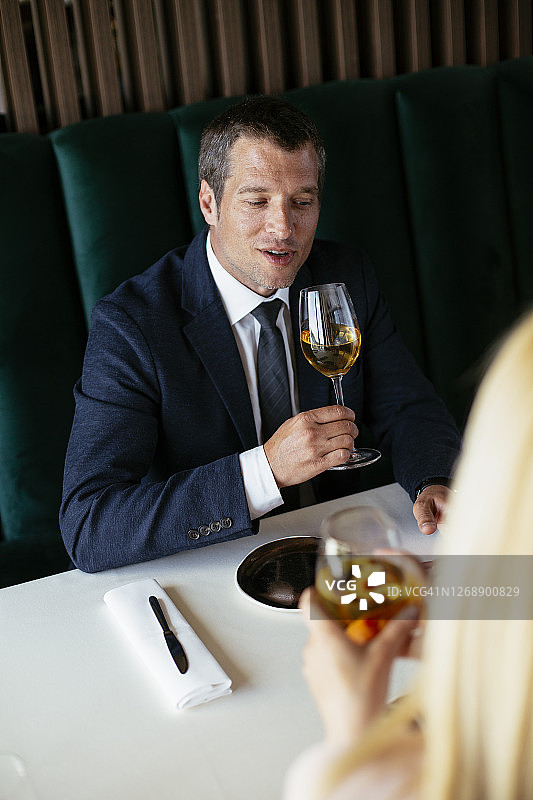 英俊的商人穿着西装在餐厅喝酒图片素材