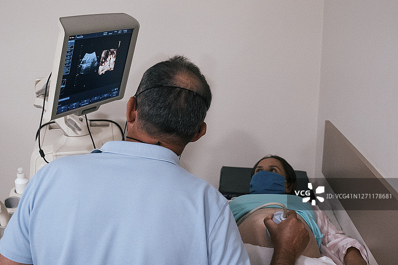 在COVID-19期间怀孕。子宫内胎儿的超声波扫描。在怀孕期间为胎儿做超声检查。2019冠状病毒病期间的体检。图片素材