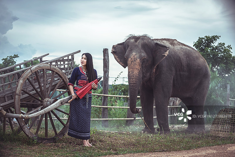 新一代亚洲美女的肖像与大象在泰国传统服装图片素材