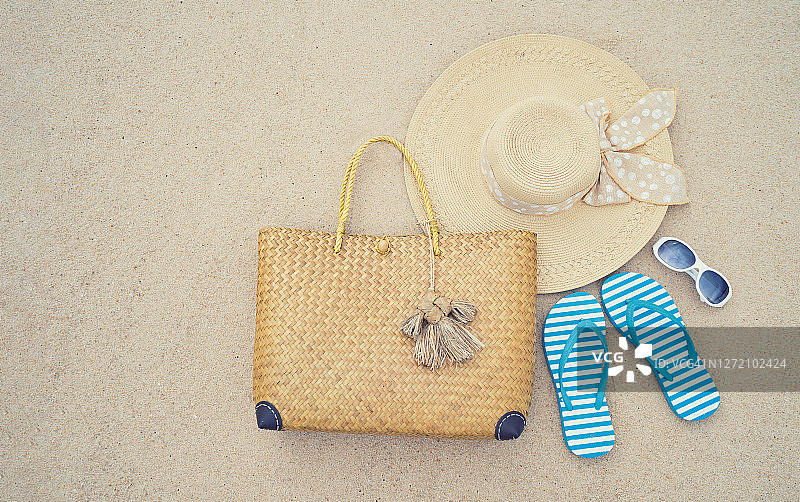 海滩配件。草帽。袋里。太阳眼镜和人字拖在热带海滩上。有趣的沙滩假日旅行。夏季。夏天的氛围。图片素材