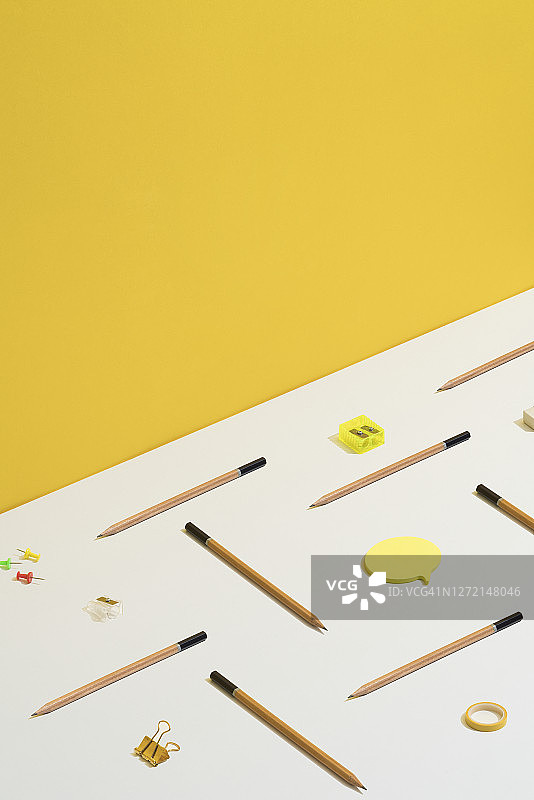 文具、办公用品平铺在黄白相间的背景上。图片素材
