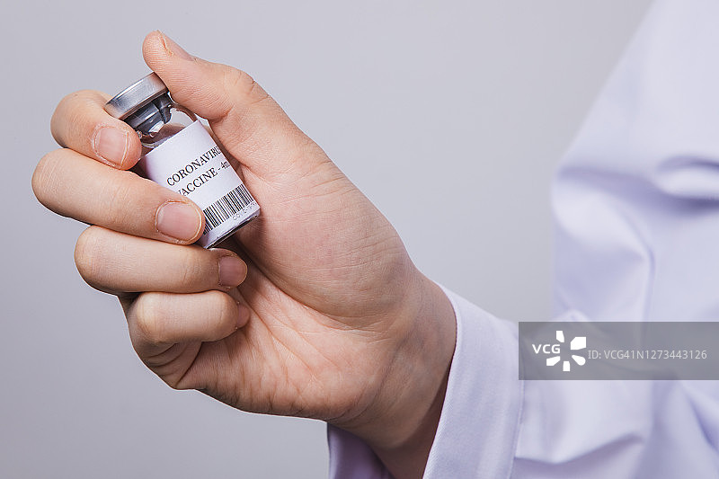 医生或科学家手里拿着一瓶冠状病毒疫苗图片素材