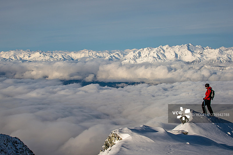 一个偏远地区的滑雪者在厚厚的粉状雪中接近悬崖边缘图片素材
