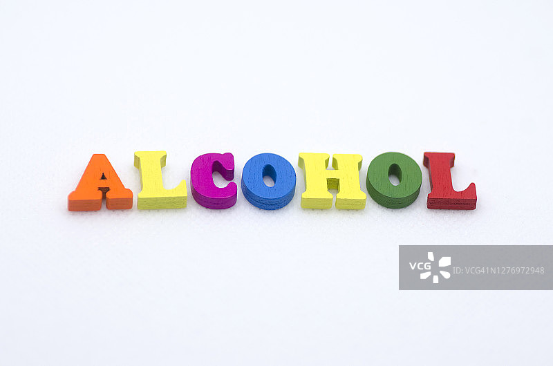 “酒精”这个词是用白色背景上的彩色木制字母拼出来的图片素材