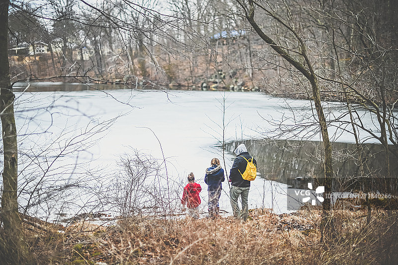 冬天，父亲和女儿们站在结冰的湖边图片素材