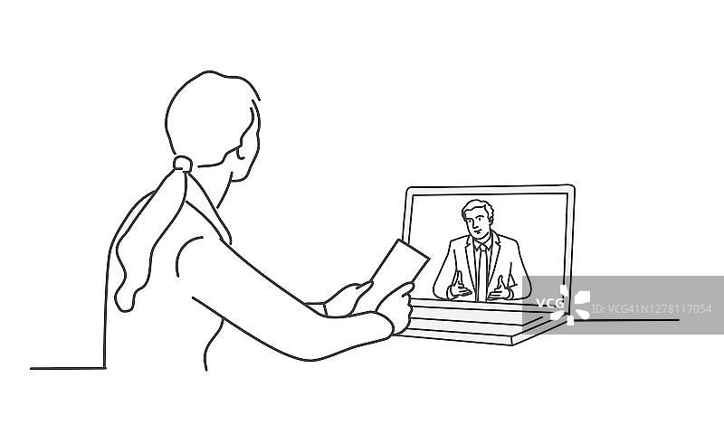 女孩坐在一张桌子前，面前是一台笔记本电脑。图片素材