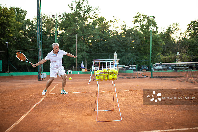 高级网球运动员在网球场上练习正手图片素材
