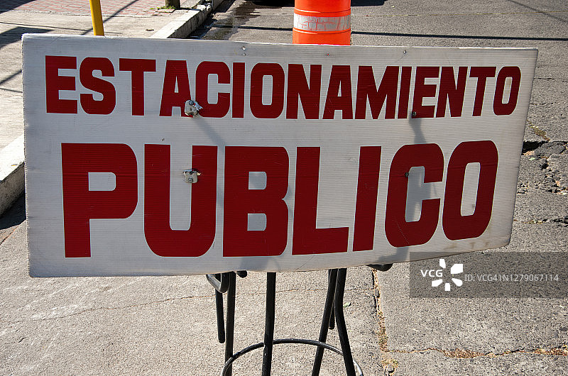 市中心道路上的一个凳子上的西班牙语标牌上写着:“Estacionamiento Publico”(公共停车场)图片素材
