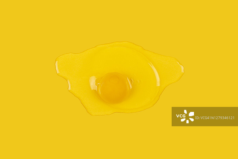 破碎的生鸡蛋在黄色背景上分离图片素材
