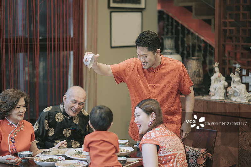 亚洲华人家庭春节团圆饭吃传统菜肴生鱼刘生图片素材