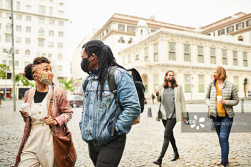 各种各样的朋友在城市里散步时一起聊天图片素材