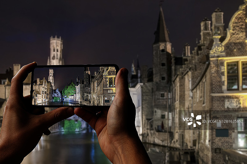 比利时布鲁日，游客在夜间拍摄布鲁日老城区的历史建筑、运河和钟楼图片素材