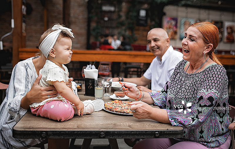 老父母和他们的女儿和孙女在餐厅吃午饭图片素材