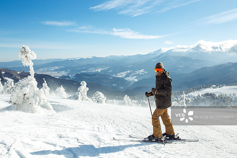 一个在山上滑雪的不错的年轻人。冬季积极的生活方式。图片素材