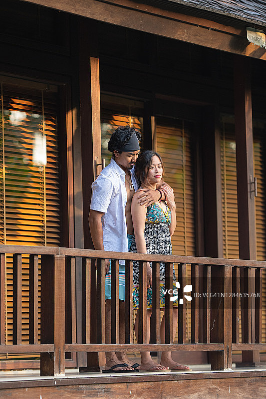 在巴厘岛度假的夫妇放松在酒店阳台日落图片素材