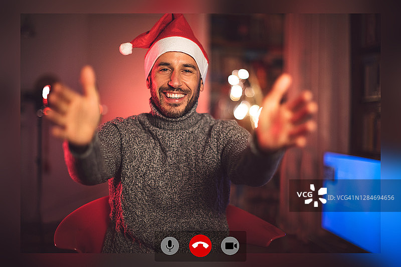 圣诞节期间，有个男人在家和家人视频通话图片素材