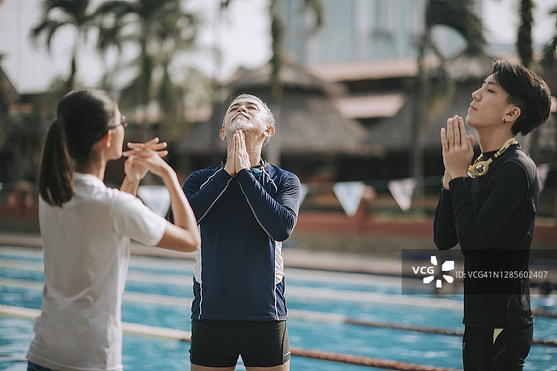 中国女教练在游泳课前做热身运动图片素材