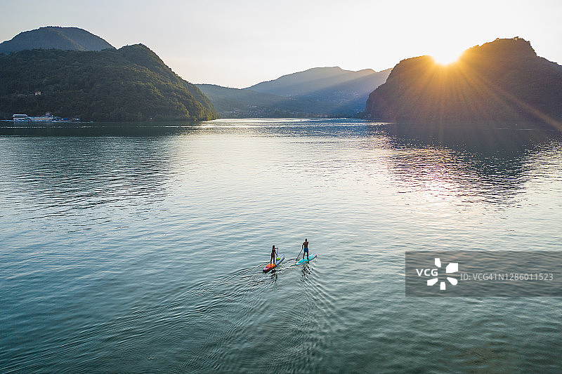 从空中俯瞰日落时分湖面上的两个划桨者图片素材