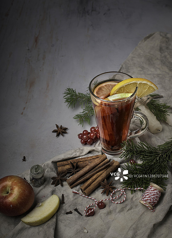 食物摄影的圣诞静物侧视图与一杯热热的葡萄酒香料和装饰在一个灰色的纹理背景与地方文本近距离图片素材