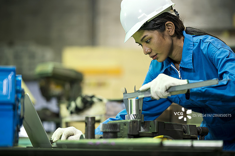 女技术员在工厂检查产品质量。质量控制管理体系。图片素材