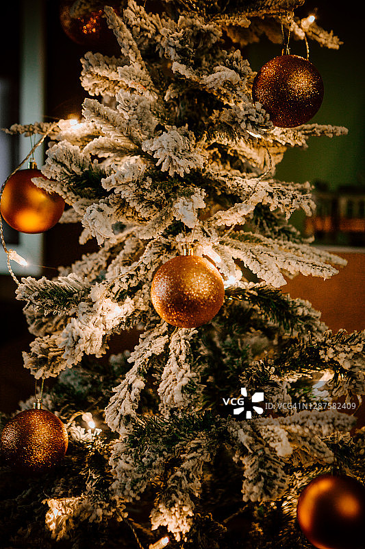 金色的圣诞球挂在家里的圣诞树上图片素材