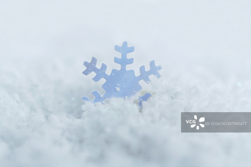 白色雪花上的蓝色五彩纸屑雪花的特写图片素材