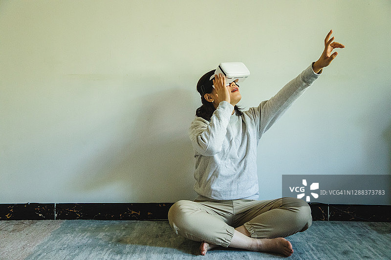 亚洲女性在家里使用虚拟现实耳机图片素材