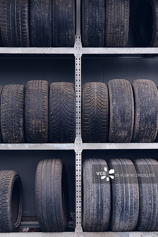汽车和卡车的旧轮胎堆成一堆，排成一排，储存起来。放弃二次利用。图片素材