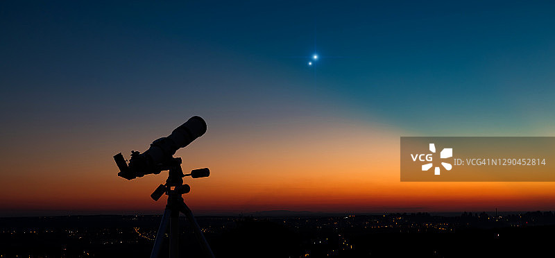 暮色中天文望远镜的剪影。图片素材