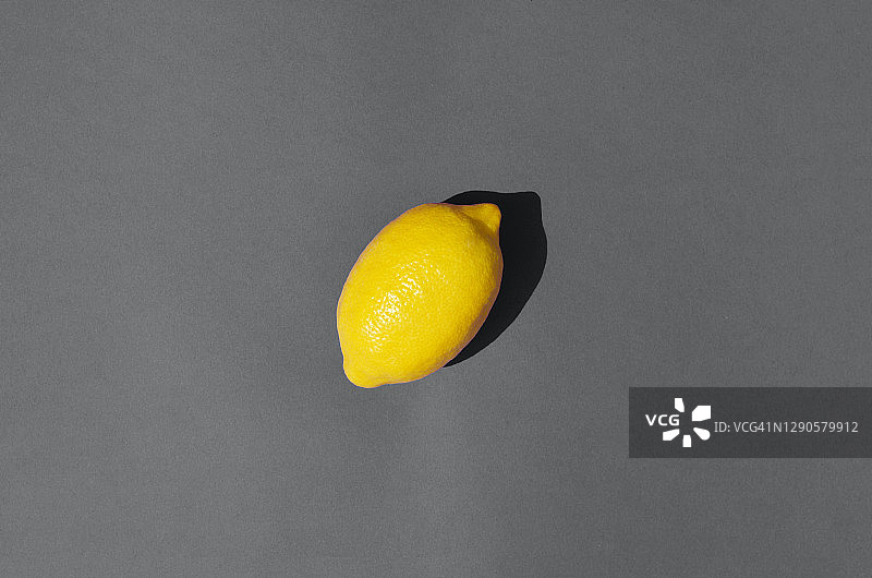 柠檬在灰色背景在一个时髦的颜色组合。图片素材