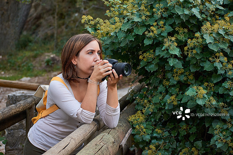 一名女子将相机架在木桥上拍照图片素材