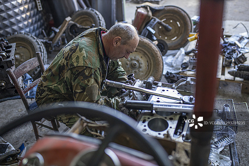 勤劳的拖拉机机修工在他的修理厂图片素材