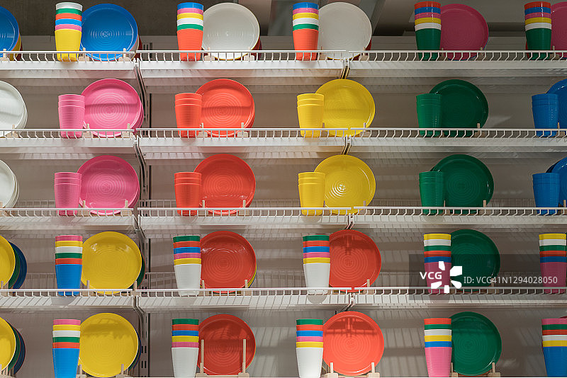 架子上五颜六色的一组塑料盘子。图片素材
