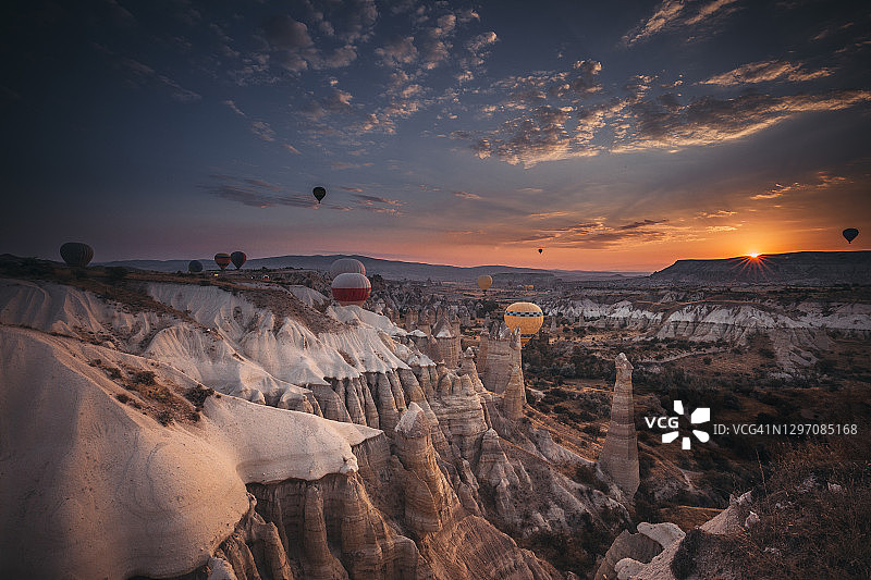 土耳其戈雷米卡帕多西亚，热气球在日出时飞过岩层图片素材