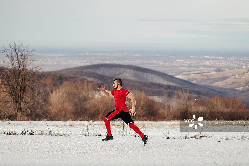 冬季，健硕的运动员在雪地上冲刺。冬天健身，健康生活图片素材