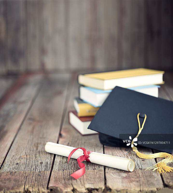 毕业帽和文凭概念上的一个木材背景图片素材