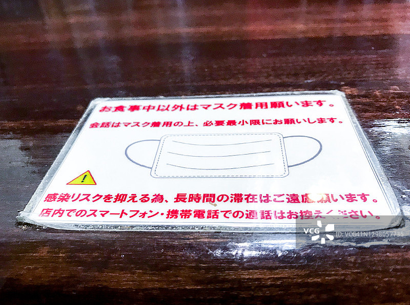 一家咖喱餐厅的柜台桌上挂着COVID-19标志图片素材