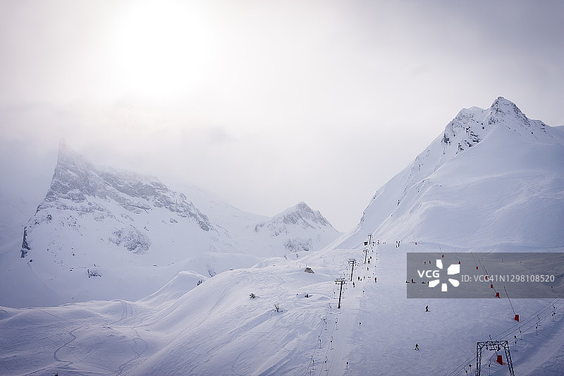 阿尔卑斯山冬季的风景。梅洛芬体育区在齐勒塔尔。以山脉为背景的滑雪场。海拔3000米的山上有雾图片素材