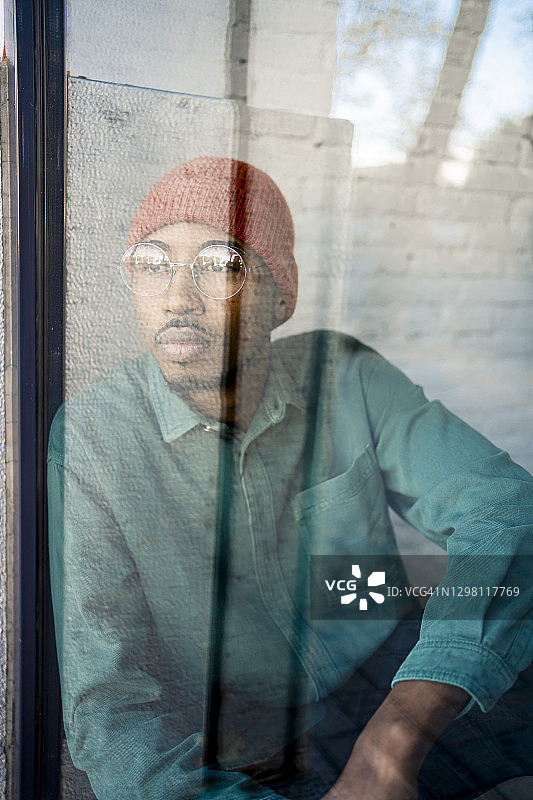 一个中年男人透过窗户往外看，在沉思图片素材